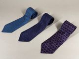 three ties are lined up on a table with a white background