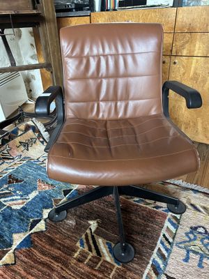Fauteuil en skaï brun posant sur 5 pieds, modèle de Charles …