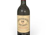 une vieille bouteille de vin posée sur une surface blanche