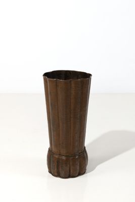 une image représentant un vase marron posé sur une surface blanche