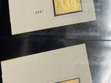 two gold stamps are on a black surface with a white background