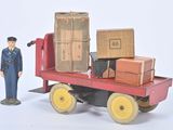 un petit bonhomme en jouet qui se tient à côté d'un petit camion en jouet