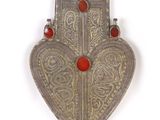 an old silver and red heart shaped pendant with red beads