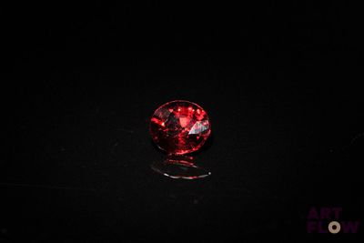 a close up of a red diamond on a black surface