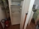 an open refrigerator in the corner of a small room