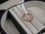 une alliance dans un écrin à bague, attachée à un cordon blanc