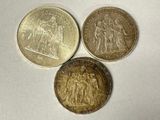 three different types of coins sitting on top of a white surface