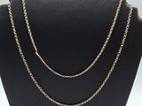 a gold chain necklace on a mannequin display