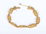 a close up of a gold bracelet on a white background