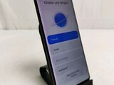 a close up of a cell phone on a stand on a table