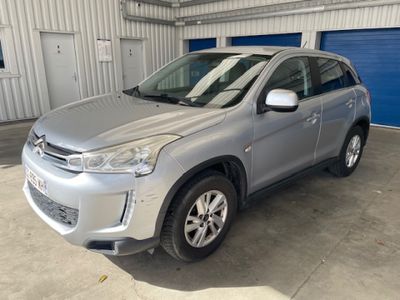 un SUV argenté garé dans un garage dont la porte est bleue