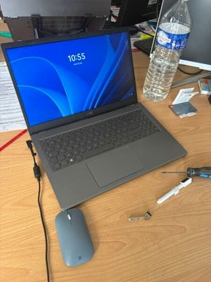 un ordinateur portable posé sur un bureau, à côté d'une souris