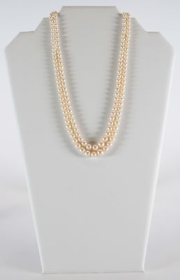 a close up of a necklace with pearls on a mannequin