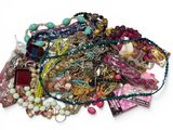 un tas de colliers et de bracelets de toutes sortes posés sur une surface blanche