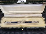 une photo d'un bracelet en diamants bleus et blancs présenté dans un écrin