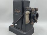 an old black camera sitting on top of a white surface