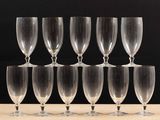 six empty wine glasses sitting on top of a wooden table