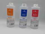 three bottles of liquid sitting next to each other on a white surface