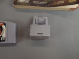 a gameboy next to a game box on a table