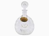 crystal decante bottle with a gold coin on the top