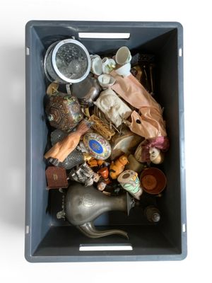 une boîte bleue remplie d'objets divers posée sur une surface blanche