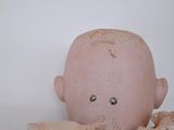 a small doll with a pink dress on it ' s head