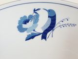 a blue and white plate with two birds on it