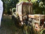 an old tractor that is sitting in the grass