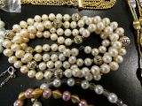 a lot of pearls and other jewelry on a table