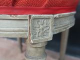 a close up of a chair with a red cushion on it