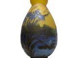 un vase jaune orné d'une peinture, posé sur une table