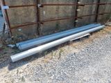 two pipes that are laying on the ground next to a fence