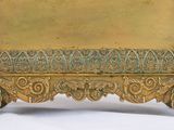a gold plate with a design on it on a white surface