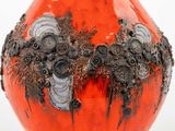 an orange vase with black and white designs on it