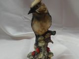 figurine en porcelaine représentant un oiseau perché sur une souche d'arbre