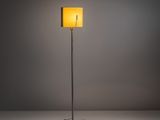le lampadaire avec un abat-jour jaune sur fond gris