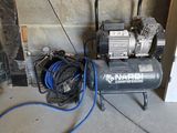 an air compressor sitting on the floor next to a wall