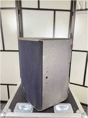 une enceinte argentée et noire posée sur un boîtier métallique