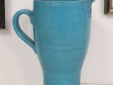 a blue cup sitting on a table next to a picture