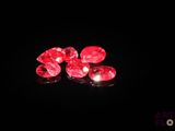 three red diamonds on a black surface in the dark