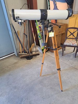 un télescope posé sur un trépied dans un garage