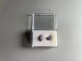 a pair of earrings sitting in a box on a table