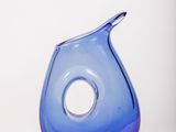 un vase en verre bleu troué