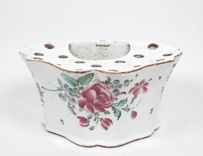 un petit vase blanc orné d'un motif de roses