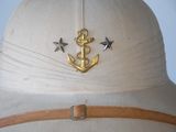 a white hat with a gold anchor and stars on it