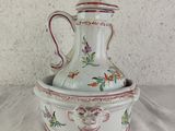 a white vase with a bird on it sitting on a table