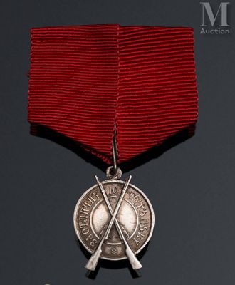 a close up of a medal with two crossed swords on a red ribbon