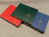 four different colored binders sitting on top of a white table