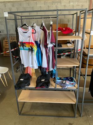 a metal rack with clothes on it in a room