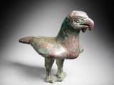 a close up of a bird statue on a white surface